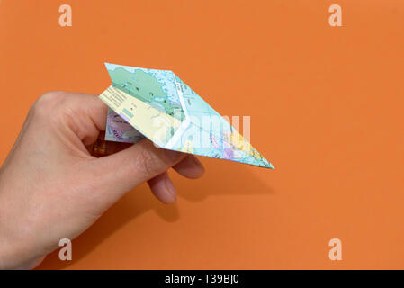 La main avec Paper planes à partir de la carte du monde sur fond de papier Banque D'Images
