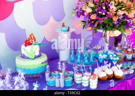 Le temps de mer thème mermaid sur la partie candy bar avec fond violet. D'anniversaire pour les filles, les adolescents. Banque D'Images