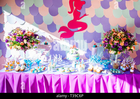 Le temps de mer thème mermaid sur la partie candy bar avec fond violet. D'anniversaire pour les filles, les adolescents. Banque D'Images