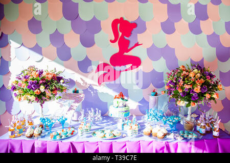 Le temps de mer thème mermaid sur la partie candy bar avec fond violet. D'anniversaire pour les filles, les adolescents. Banque D'Images