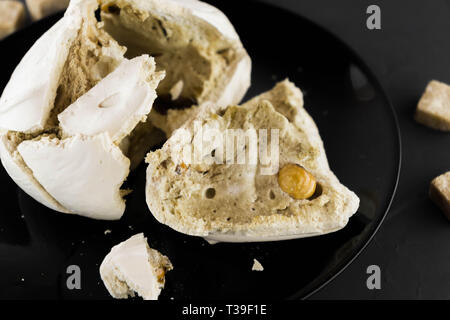 La meringue avec les écrous sur une plaque noire. Mode Macro. Le sucre de canne. Candy. Banque D'Images