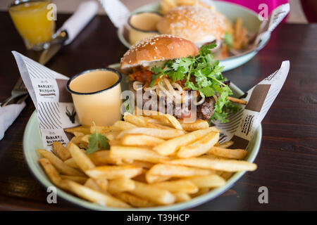 Cape Town, Afrique du Sud. 28 mars 2019. Un boerie burger et des frites avec une tasse de l'émail. Banque D'Images