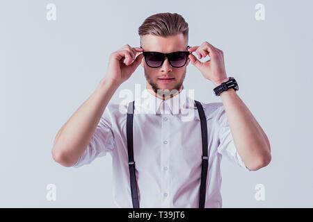 Beau et élégant, l'Homme à lunettes vêtements classique vêtu de noir alors qu'il se tenait à l'arrière-plan gris. Homme élégant en chemise blanche et suspendre Banque D'Images