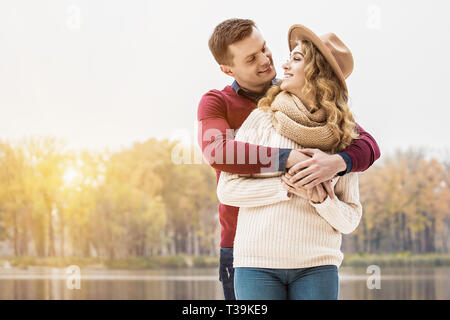 T'aime beaucoup. Portrait of beautiful hugging woman tout en se tenant à l'extérieur. Bel homme embrassant son attractiv Banque D'Images