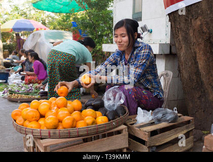 Femme vendant des oranges au marché intérieur à Yangon, Myanmar Banque D'Images
