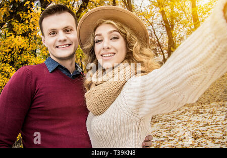 Pour l'heure. selfies Coup horizontal de cheerful blonde woman sur selfies appareil photo avec son beau petit ami. Couple à l'extérieur. selfies Ensemble Banque D'Images