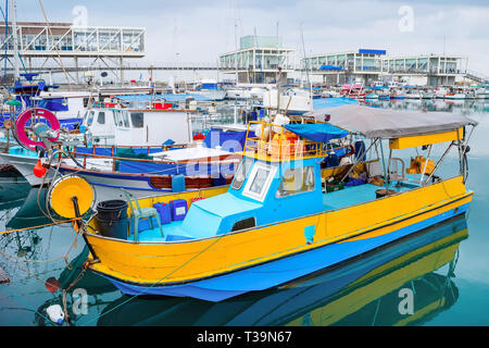 Bateaux de pêche colorés amarrés dans Limassol marina avec des restaurants sur la jetée, à Chypre Banque D'Images