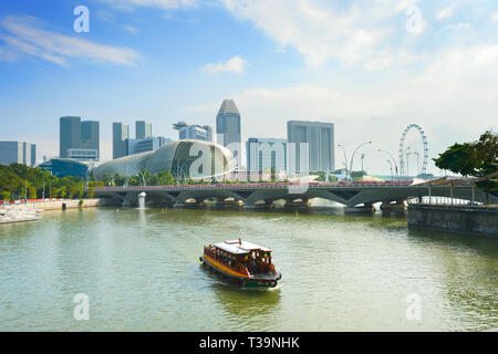 Bateau de croisière touristique par Singapour Marina Bay Harbour avec grande roue circulaire, Théâtre de l'Esplanade sur la baie et sur la ville en arrière-plan Banque D'Images