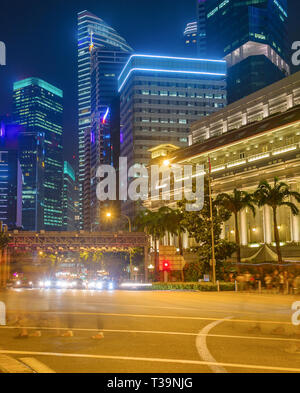 Métropole de Singapour, centre-ville illuminée en nuit, tas de gens dans le motion blur traversant la route de la ville, les bâtiments de l'architecture moderne en ba Banque D'Images