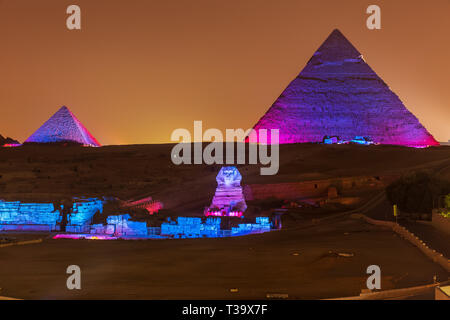 Les Pyramides et le Sphinx dans les lumières de la nuit, Giza, Egypte Banque D'Images