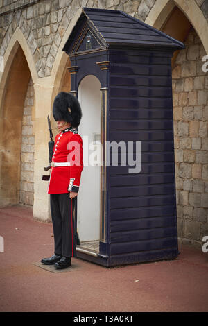 Windsor, Royaume-Uni - décembre 2018. Une sentinelle de la garde des grenadiers dans son uniforme iconique à l'extérieur de porte du château de Windsor. Banque D'Images