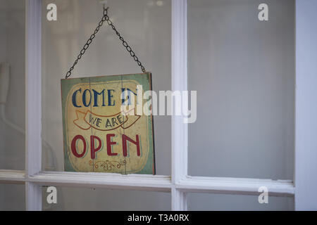 Pancarte ouvert sur un magasin porte avec un cadre en bois blanc. Le format paysage. Banque D'Images