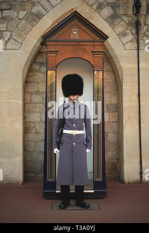 Windsor, Royaume-Uni - décembre 2018. Une sentinelle de la garde des grenadiers dans son uniforme iconique à l'extérieur de porte du château de Windsor. Banque D'Images