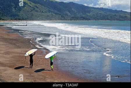 Un couple de surfeurs sur la plage avec leurs planches sur leur tête. Banque D'Images