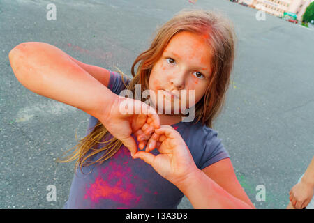 Heureuse jeune fille couverte de peinture coloré sec au festival Holi Banque D'Images