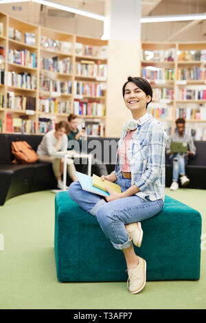 Cheerful student girl in bibliothèque moderne Banque D'Images