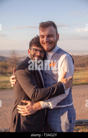 Deux homme, souriant et heureux gay couple hugging outdoors dans la nature. Banque D'Images