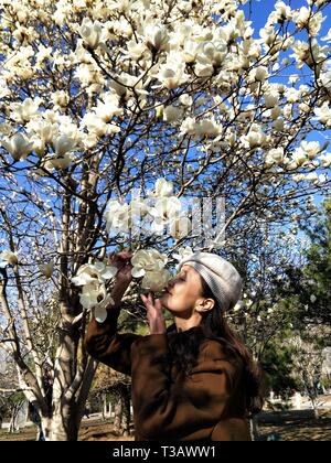 Beijing, Chine. Mar 29, 2019. Une femme renifle fleurs au Beijing International Sculpture Park dans le district de Shijingshan de Beijing, capitale de la Chine, le 29 mars 2019. Credit : Wei Mengjia/Xinhua/Alamy Live News Banque D'Images