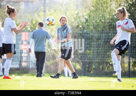 Marienfeld, Allemagne. Le 08 Avr, 2019. Soccer : les femmes, l'équipe nationale, la formation finale avant le match international contre le Japon. Martina Voss-Tecklenburg (M), l'entraîneur national, passe derrière les joueurs. Crédit : Sébastien Gollnow/dpa/Alamy Live News Banque D'Images