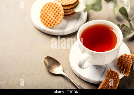 Tasse de thé avec syrupwaffles cookies Banque D'Images