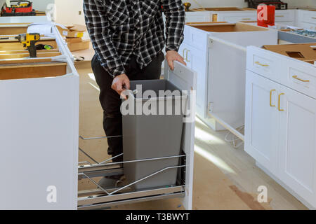 Montage de meubles mains homme poubelle dans la cuisine Banque D'Images