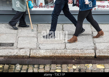 Les piétons circulant sur la chaussée dans une rue. Banque D'Images