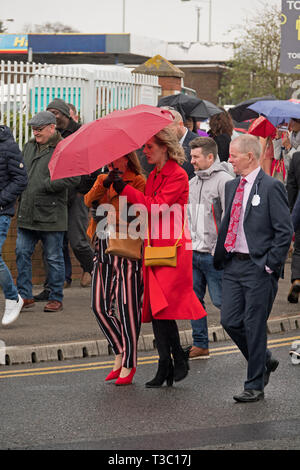 Les femmes s'habillent pour une journée sur un 1er jour froid et humide à la Réunion nationale 2019 Grand Aintree Banque D'Images