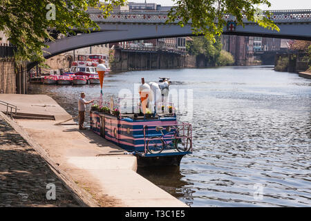 Fixation de l'homme signe sur l'ensemble de la crème glacée Moo bateau amarré sur les rives de la rivière Ouse dans York avec Lendal Bridge en arrière-plan Banque D'Images