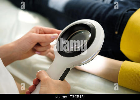 Dermatologue à l'aide d'une loupe professionnelle tout en faisant l'examen de la peau, contrôle sur la main. Les taupes bénigne Dermatologist examining birthmarks un Banque D'Images