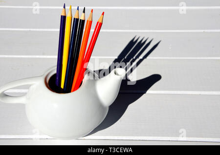 Ensemble de crayons de couleur en bois blanc dans un bol, sur une table en bois Banque D'Images