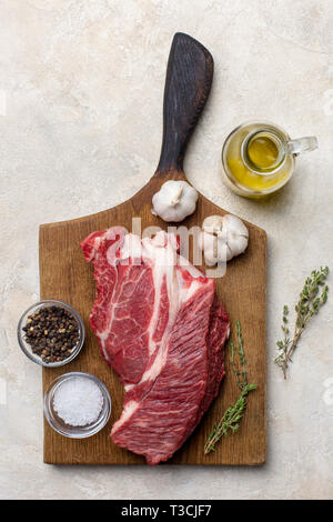 Coupe de bœuf cru sur bois à fond clair. Concept de fiche de la nourriture. Vue d'en haut Banque D'Images