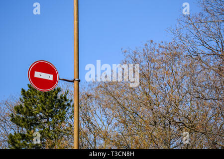 Panneau routier pas d'entrée contre le ciel bleu et les arbres. Banque D'Images