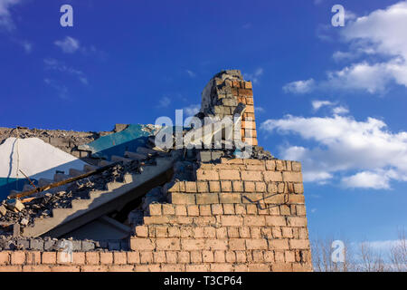 Les ruines d'un bâtiment détruit dans la ville dans le contexte d'un ciel bleu. La double-ISO photo. Banque D'Images