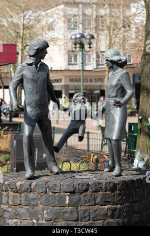 Une sortie en famille - une sculpture en bronze de deux parents tenant les mains d'un enfant par John Ravera, érigé sur la place Mell, à Solihull, en Angleterre Banque D'Images