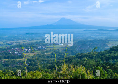 Bassin de Yogyakarta et volcan Merapi se dessinent dans le lointain. Merapi est un volcan très actif Banque D'Images