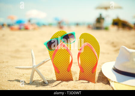 Près de l'étoile de tongs et lunettes de soleil sur la plage Banque D'Images