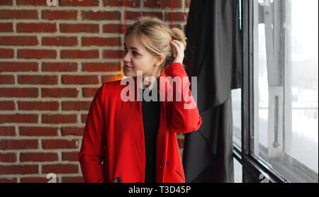 Businesswoman sourire heureux porter veste rouge - femme de plus office de mur de brique Banque D'Images