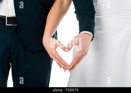 Portrait de la jeune mariée et se toilettent montrant coeur signe avec mains isolated on white Banque D'Images