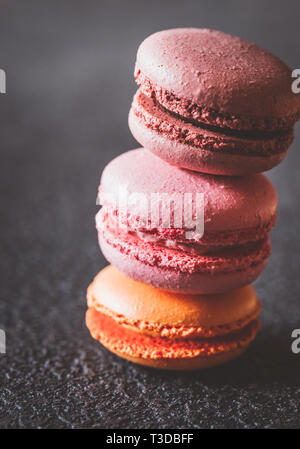 Macarons colorés sur le fond sombre Banque D'Images