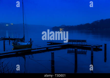 Le Baldeneysee à Essen, en Allemagne, l'hiver, la pluie, lonely voilier sur un quai vide, Banque D'Images