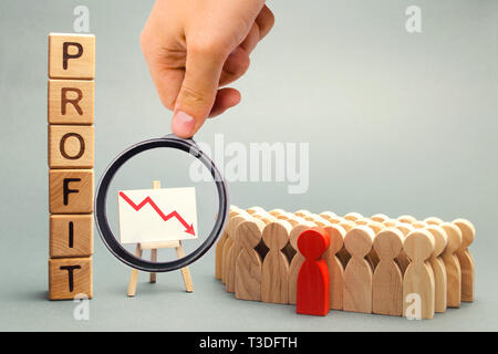Blocs en bois avec le mot profit, flèche vers le bas et l'équipe commerciale. L'entreprise échoue et la faillite. Baisse de profit. La perte de l'investissement. C économique Banque D'Images