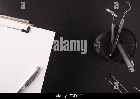 Dentiste noir table avec des outils. Vue d'en haut. Composition horizontale. Banque D'Images