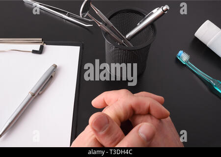 Vue du dessus de la table d'un dentiste médecin faire une consultation médicale avec ses mains sur la table. Top View. Composition horizontale. Banque D'Images