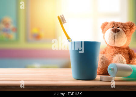 L'hygiène orale pour les enfants dans la chambre des enfants avec un éléments de nettoyage sur la table en bois et de jouets en peluche. Composition horizontale. Vue avant Banque D'Images