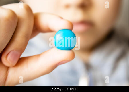 Ronde, multicolore, chocolats. Close-up. Un enfant est titulaire d'un bonbon Banque D'Images