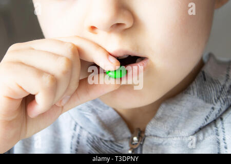 Ronde, multicolore, chocolats. Close-up l'enfant mange des bonbons Banque D'Images