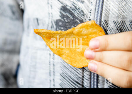 L'enfant tient dans sa main. Close-up. La malbouffe. Banque D'Images