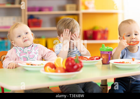 Les bébés ont le déjeuner pépinière en maternelle. Garçon enfant refuse de manger. Banque D'Images