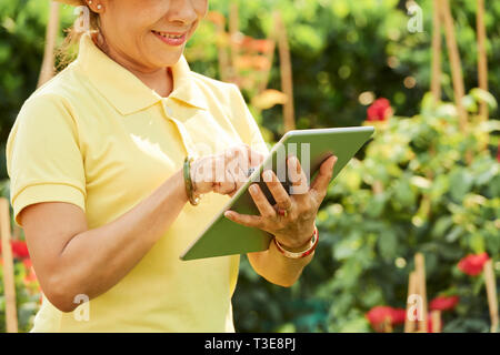 Jardinier souriant avec tablt ordinateur Banque D'Images