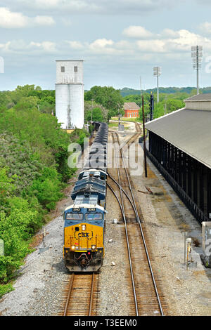 La CSX Transportation ET GE44AH locomotive diesel tire un long train de charbon dans des wagons-trémie de charbon grâce à Montgomery, en Alabama, USA, triage actif. Banque D'Images